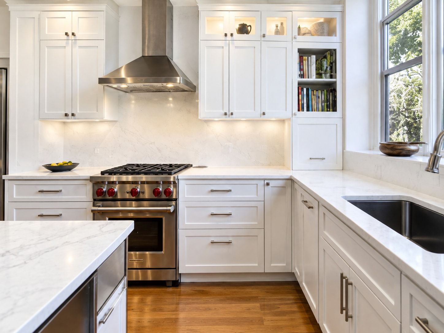 Kitchen with white shaker cabinets, a stainless steel range and hood, and a light marble-look countertop.